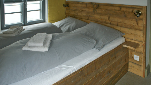 Bauholz-Bett niedrig | Bauholz-Möbel | überbreites Kopfteil | Gerüstbohlen | Hostel-Einrichtung